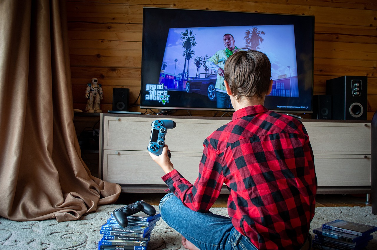 Young boy sat in front of a TV playing Grand Theft Auto on the PlayStation 4