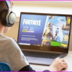 Boy playing Fortnite on a laptop.