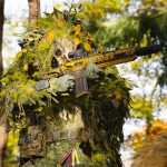 Call of Duty: MW4 DMZ : Les développeurs assurent un meilleur "feeling" des armes face à la concurrence. A screenshot of a Call of Duty: Modern Warfare 4 soldier holding a rifle in a ghillie suit.